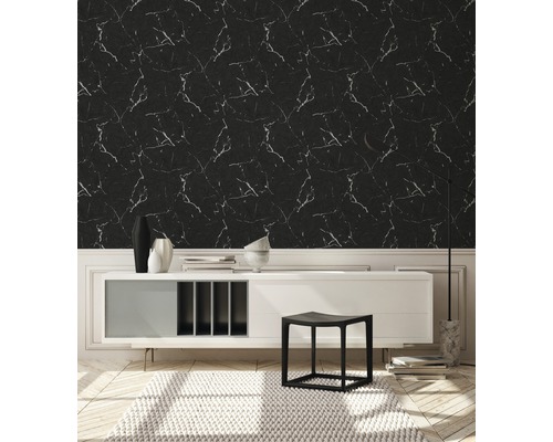 Een kamer met een wand met marmer behang, een dressoir en een tapijt.