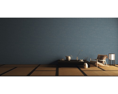 Woonkamer met blauw behang, tafel, theeservies, fauteuil en lamp