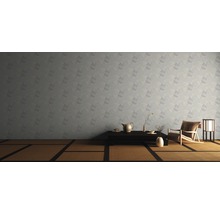 Een woonkamer met een patroonbehang, een tatamivloer, een lage tafel en een fauteuil.