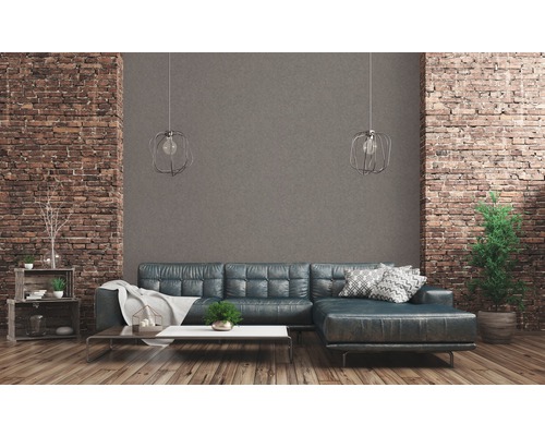 Woonkamer met bank, salontafel en decoratie voor een bakstenen muur