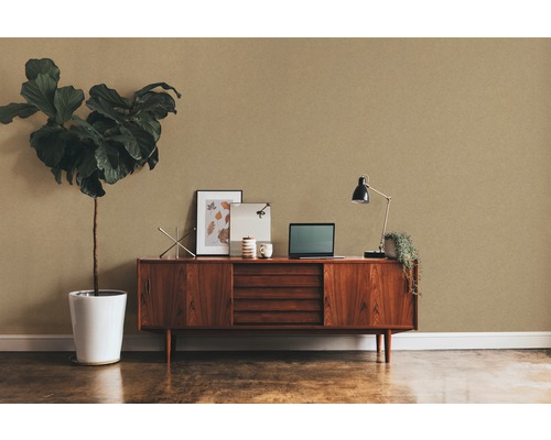 Woonkamer met bruin behang, dressoir, kamerplant en bureaulamp