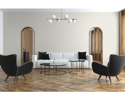 Woonkamer met bank, fauteuils, salontafels, plafondlamp en houten vloer