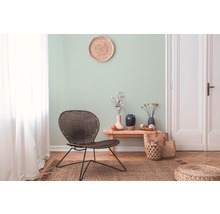 Woonkamer met rotan meubels en een licht wanddesign voor een vriendelijke sfeer.