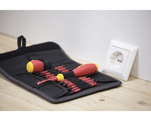 Schroevendraaierset in gereedschapstas naast stopcontact