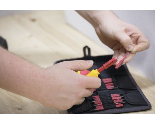 Persoon gebruikt een striptang om een kabel te strippen voor een gereedschapstas