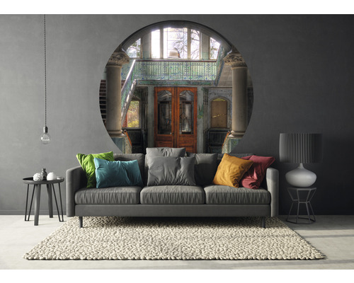 Woonkamer met bank, vloerkleed en muurschildering met gebouwgezicht