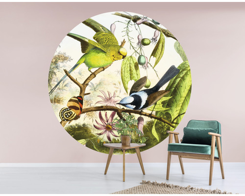 Ronde wanddecoratie met vogel-, vlinder- en plantmotief in een woonkamer