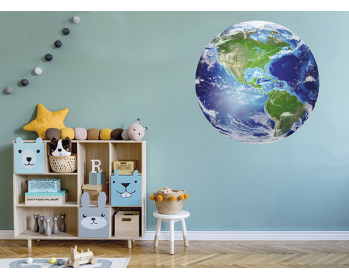 Kinderkamer met muursticker van een wereldbol, rek en speelgoed