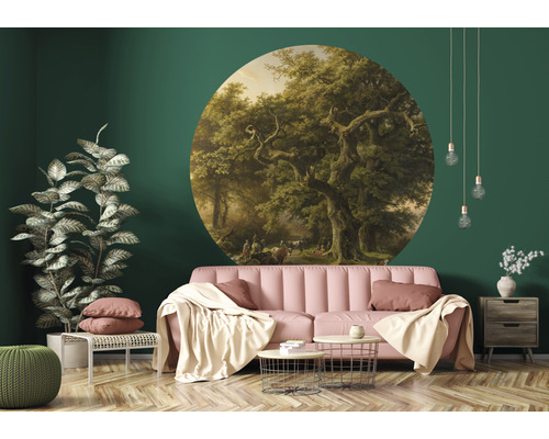 Woonkamer met een rond fotobehang met een boslandschap, een bank, een bijzettafel en een kamerplant