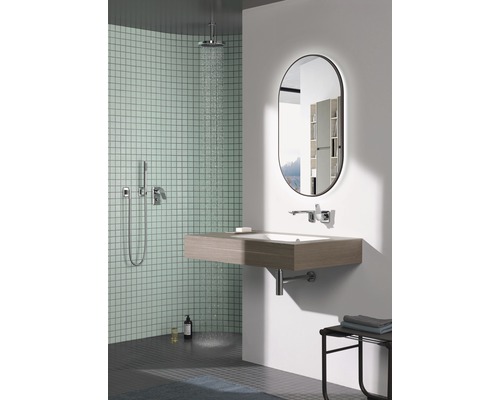 Lichte badkamer met douche, wastafel en spiegel