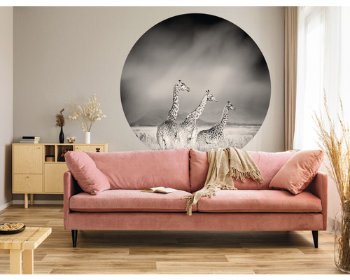 Woonkamer met roze bank, houten tafel en muursticker met giraffemotief