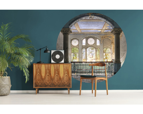 Woonkamer met een vintage kast, een kamerplant en wanddecoratie met architecturale elementen.