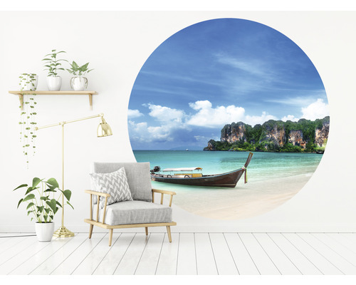 Woonkamer met fauteuil, vloerlamp, plank met planten en muursticker met strandmotief