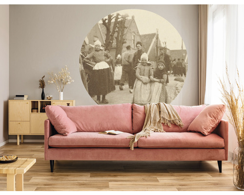 Woonkamer met roze bank, dressoir en wanddecoratie met historische foto