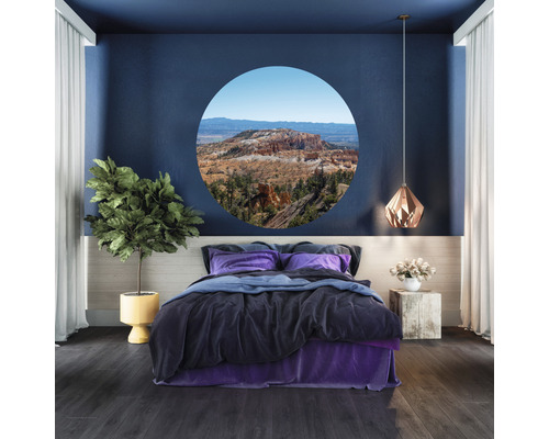 Slaapkamer met bed, plant en muurschildering met landschapsweergave