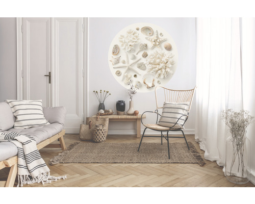 Woonkamer met bank, stoel, vloerkleed, tafel en muursticker met schelpen