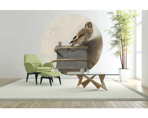 Moderne woonkamer met groene fauteuil, voetenbank, houten tafel en muurschildering