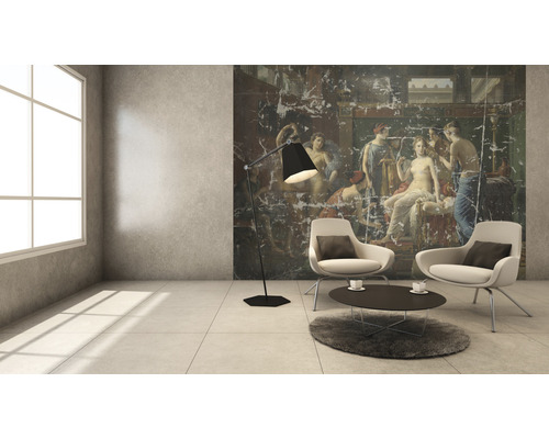 Woonkamer met muurschildering, fauteuils, staande lamp en vloerkleed