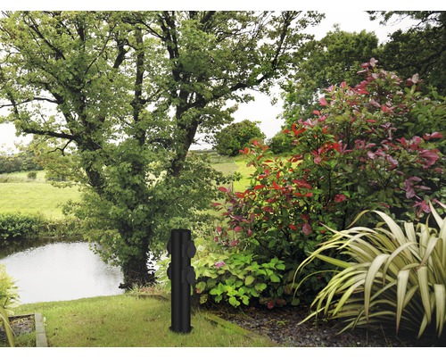 Tuinscene met boom, vijver en een zwarte tuinzak met stopcontacten