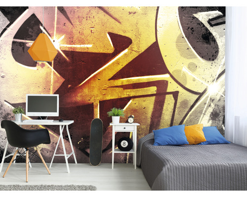 Woonkamer met bureau, bed en muurbehang in graffitistijl