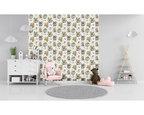 Kinderkamer met behang met dierenmotieven, commode, schommelstoel en speelgoed