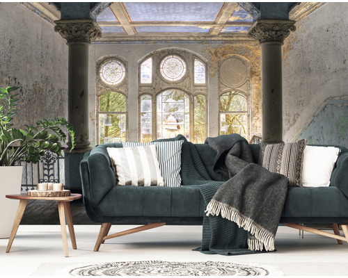 Woonkamer met bank, kussens, deken en wandbehang met architectuurpatroon