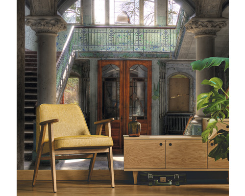 Interieurfoto van een kamer met een fauteuil, kast en decoraties in een gebouw met een trappenhuis