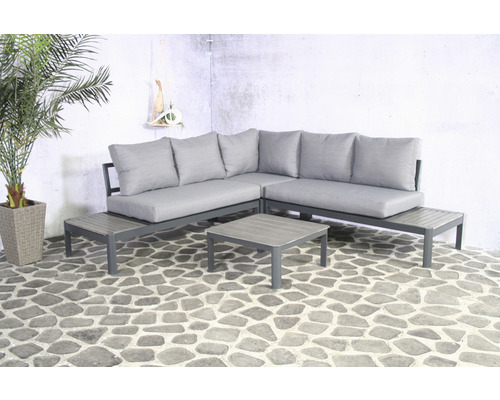 Grijze tuinlounge met hoekbank, kussens en tafel op een terras.