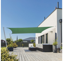Buitenkant met zonnescherm, terras en tuinmeubelen voor een woonhuis.