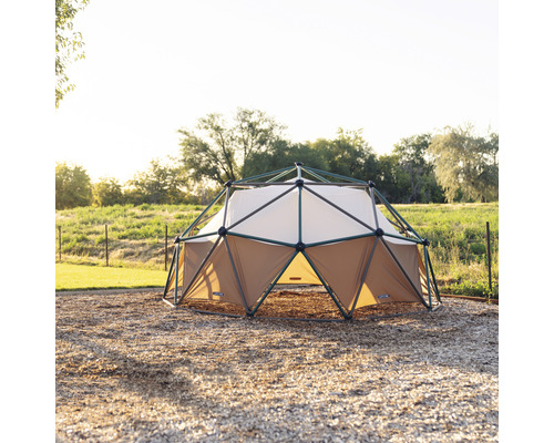 Geodetische koepelspeelplaats met bruin en wit textiel en een donkergroen frame op een speelplaats