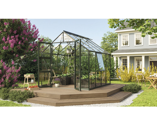 VITAVIA Tuinkas Olymp 6700 veiligheidsglas 3 mm smaragd, 257x261x254 cm Tuinkas op een houten terras in een tuin met planten en een woonhuis op de achtergrond.