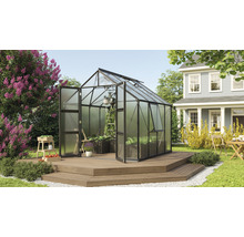 Kas op houten terras in een tuin met huis