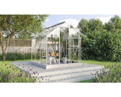 Kas in de tuin met planken en tuingereedschap