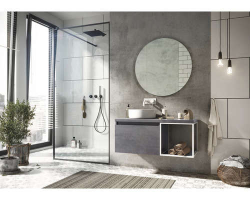 Lichte badkamer met douche, wastafel, spiegel en decoraties.