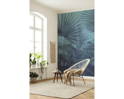 Woonkamer met raam, planten, decoratie, vloerkleed, stoel en fotobehang met plantenmotieven