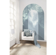Woonkamer met wolkenmuursticker, fauteuil, kussens, deken en tapijt