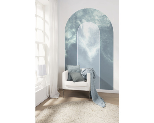 Woonkamer met wolkenmuursticker, fauteuil, kussens, deken en tapijt