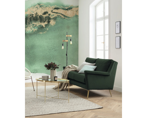 Lichte woonkamer met groene bank, salontafel en behang met motief