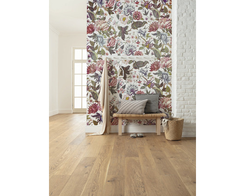 Lichte kamer met bloemenbehang, houten vloer, zitbank en decoraties.