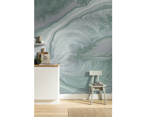 Woonruimte met patroonbehang, stoel en keukenelementen