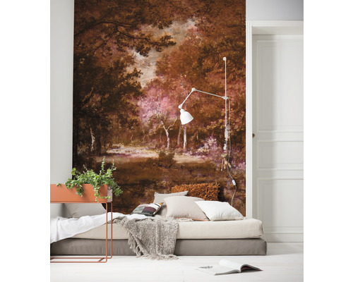 Een slaapkamer met een fotobehang van een boslandschap, een bed met kussens en een sprei, en een vloerlamp.