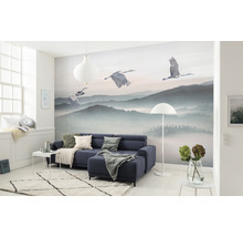 Woonkamer met fotobehang berglandschap en kraanvogels, bank, tapijt en decoratie.