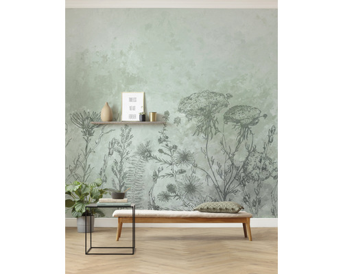 Wanddecoratie met bloemenbehang, zitbank en bijzettafel in een lichte ruimte.