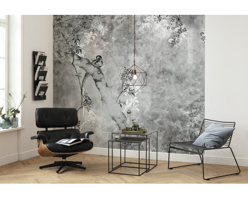 Woonkamer met patroonbehang, fauteuil, bijzettafel en lamp