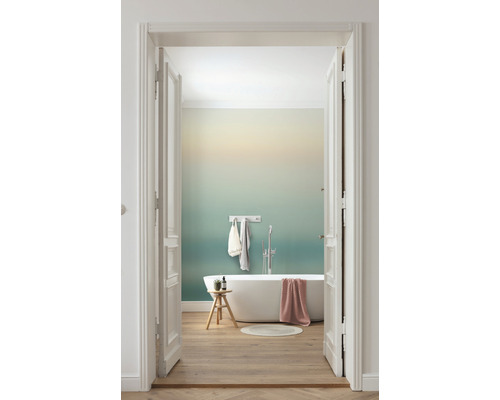 Badkamer met bad, kruk en houten vloer achter open witte deur