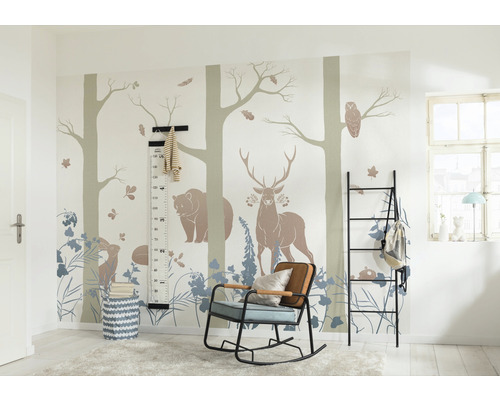 Kinderkamer met bosdiermotieven op de muur, een zwart rek, een schommelstoel en een meetlat.