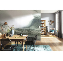 Woonkamer met fotobehang berglandschap, houten tafel, stoelen en boekenrek