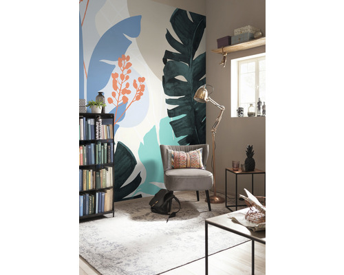 Decoratieve kamer met fotobehang met plantenmotieven, fauteuil, boekenkast en staande lamp