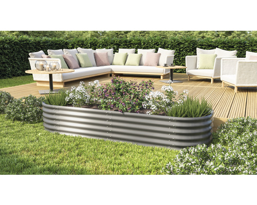 Metalen plantenbak met planten op een terras met tuinmeubelen