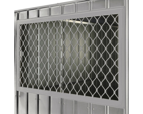 Detailopname van een metalen raam met raster voor een tuinhuis